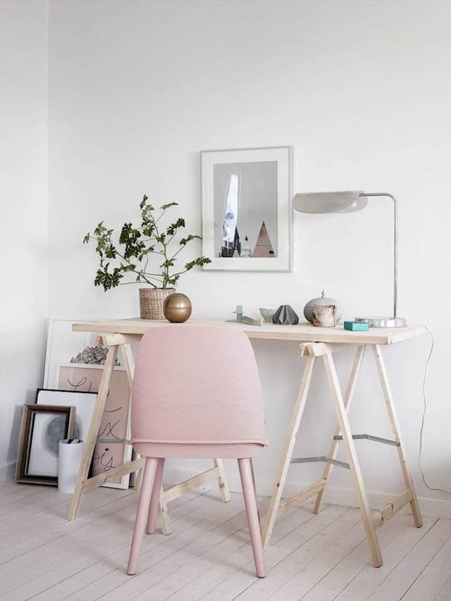 Accent chair An accent pink chair in front of a simple wooden table.