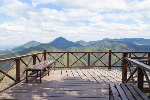 A beautiful and wooden balcony overseeing a view of nature and mountains