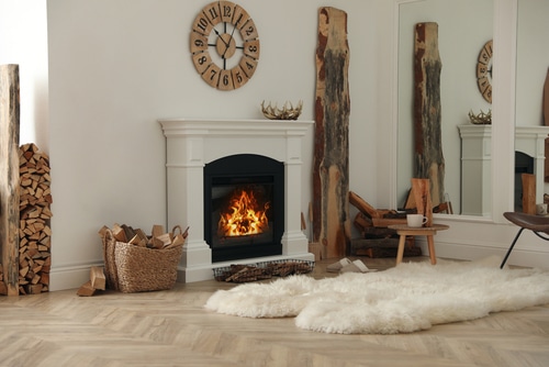 A beautiful classic white fireplace with woos on a woven basket.