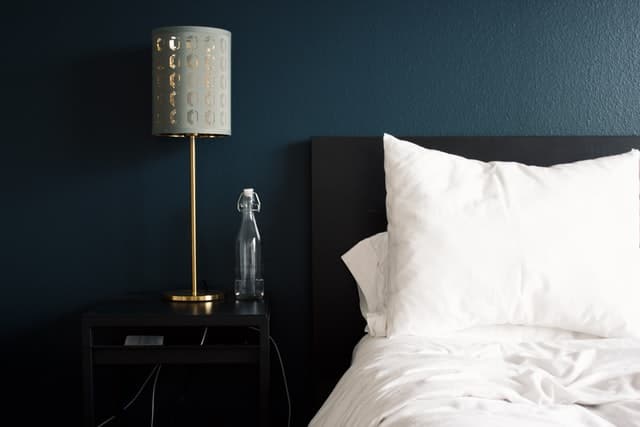 bed table lamp Simple gray bed table lamp against a dark blue wall