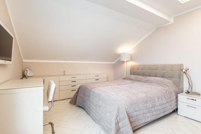 A white colored cabinet for bedside storage.