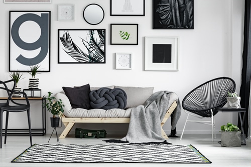 A bright living room with neutral tones like white, soft grays and contrast of black.