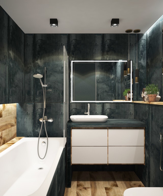 A cozy black marble bathroom walls contrasted to a big white tub.
