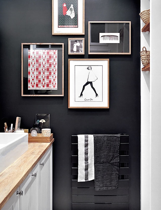 A black wall creates high contrast that helps draw focus on the photo frames.