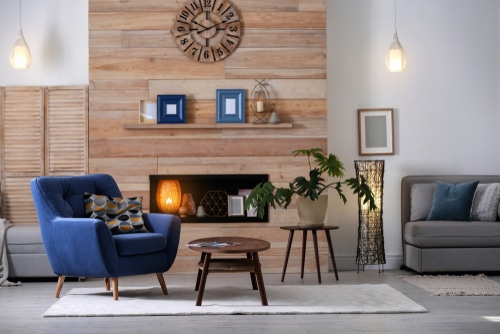 A cozy blue chair beside a built-in fireplace.