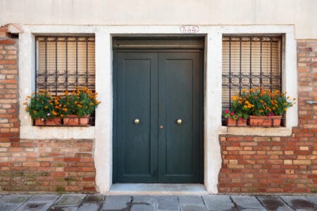 A black double door for a brick house