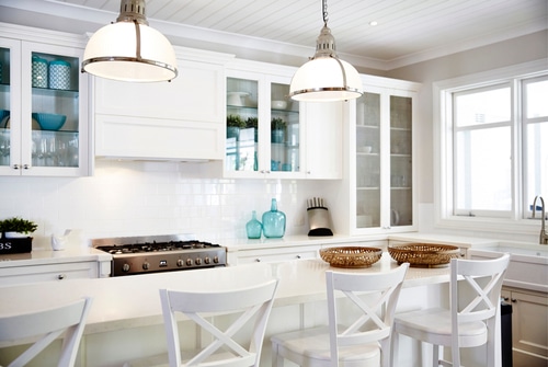 A very airy and bright kitchen with the use of white cabinetries and glass doors.