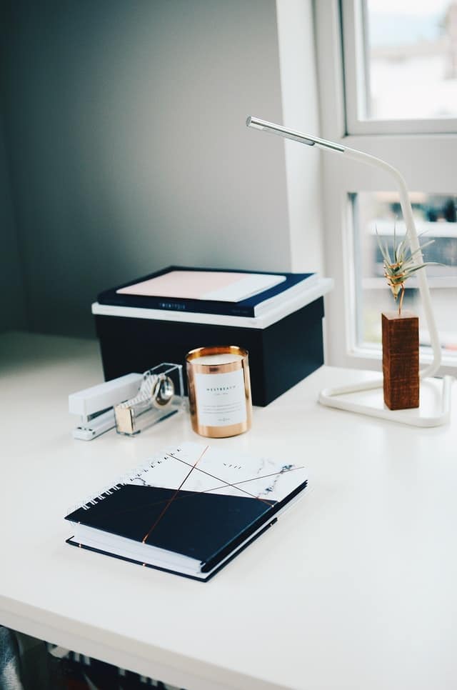 Notebook, candle jars and office supplies on the table