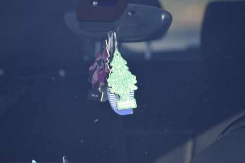 Christmas tree shaped car freshener hanging in front