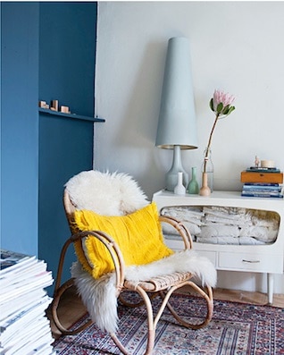 comfortable chair A comfortable rattan chair with a faux fur and yellow throw pillow