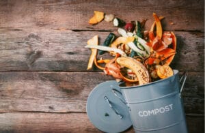 A compost can with materials that you can use spilling out of it