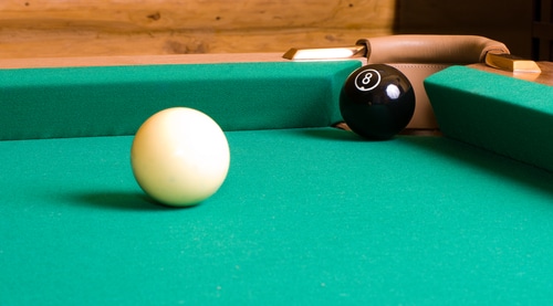 The cue and eight pool ball on the corner
