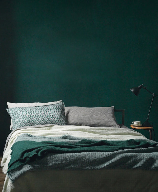 Dark green bedroom wall and green duvet