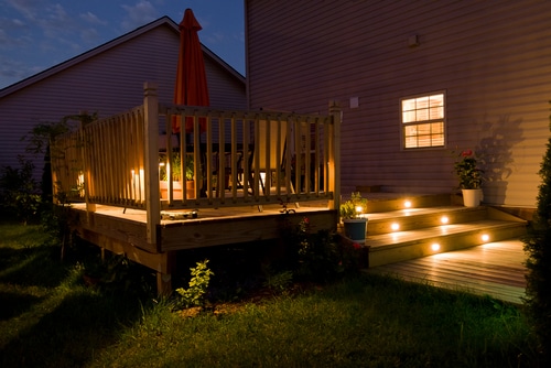 A beautifully lit house deck at night.