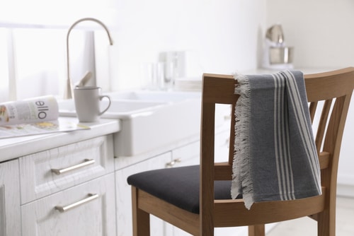 A striped dry towel placed on chair beside the kitchen sink.