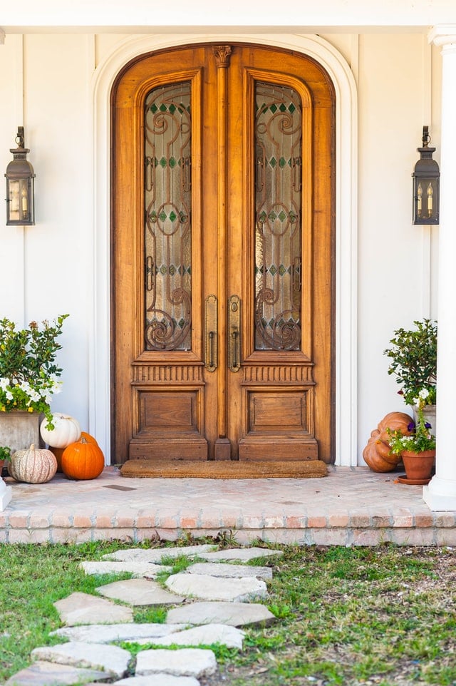 elegant brown door An arched front door using a beautifully carved wood.