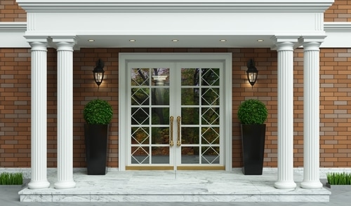 A house front entrance with boxwood decorations