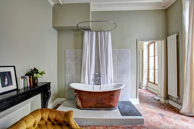 a large bathroom with a bathtub that is painted red