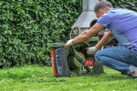 An adult man operating a lawnmower