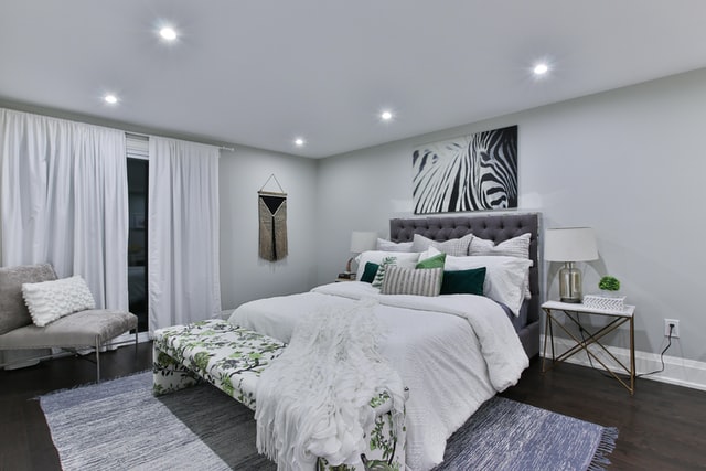 A black and white bedroom with minimal styling elements and a touch of green on pillows.