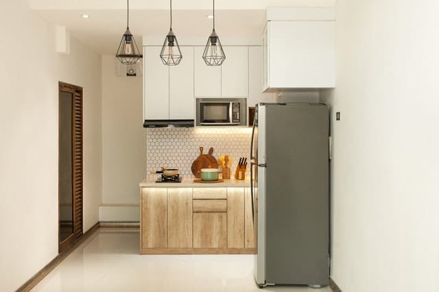Simple but functional kitchen with clean  furnishings and stainless appliances.