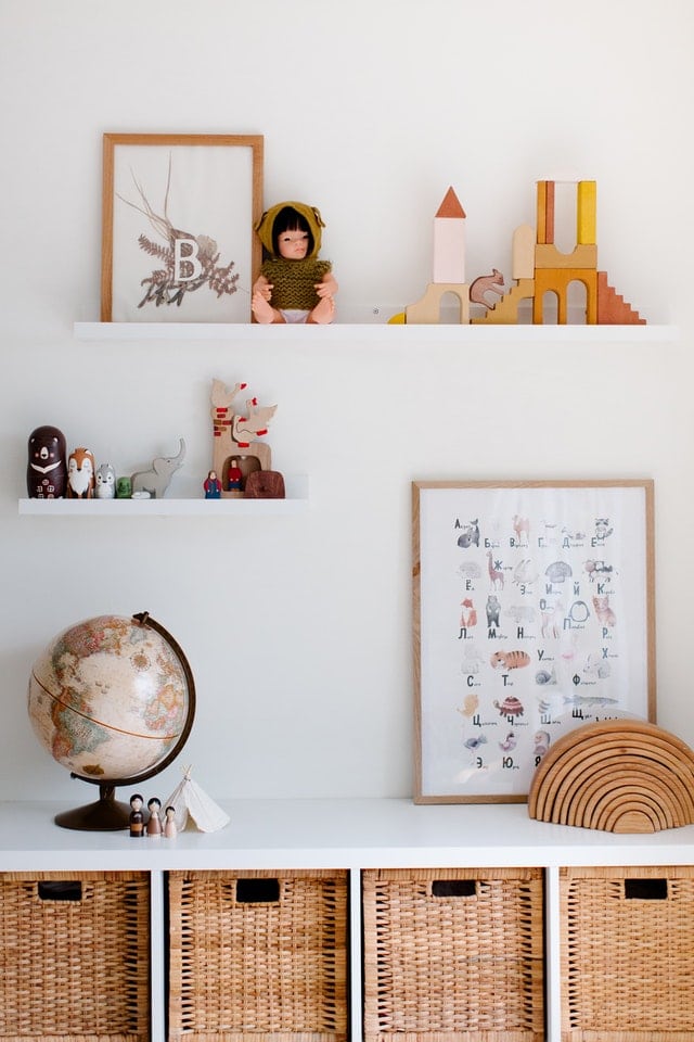 Coordinated natural wood colors of toys and decor against a simple white wall.