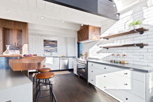 Mix of minimalist and industrial kitchen styling with a use of wooden stools.