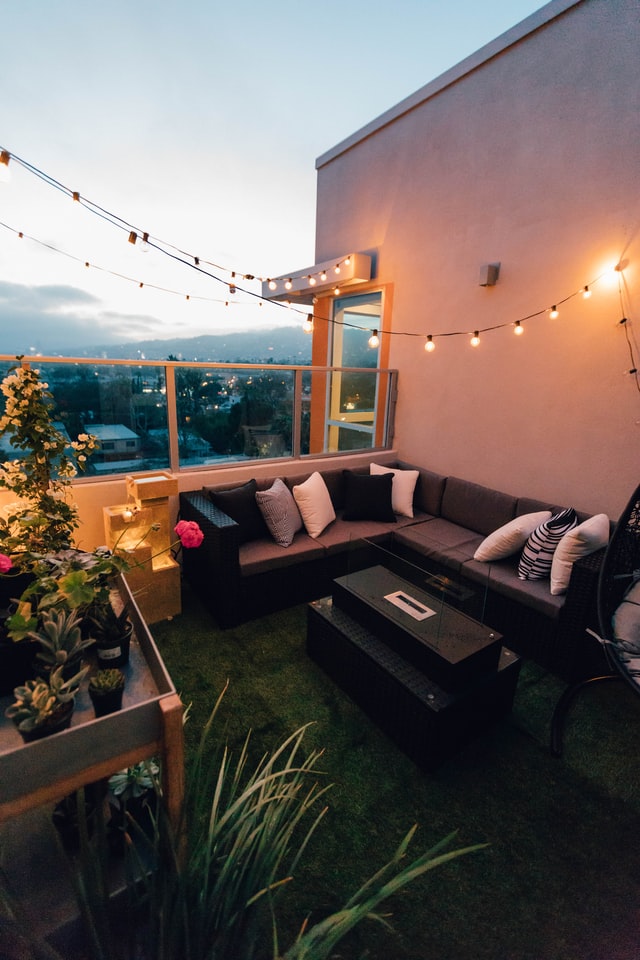 An outdoor lounge area with string lights during night time