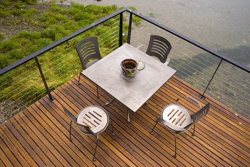 An outside patio with metal railings, tables and chairs