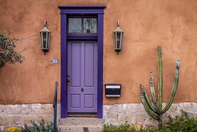 purple door A very unique contrast of a purple door and peachy orange wall paint.