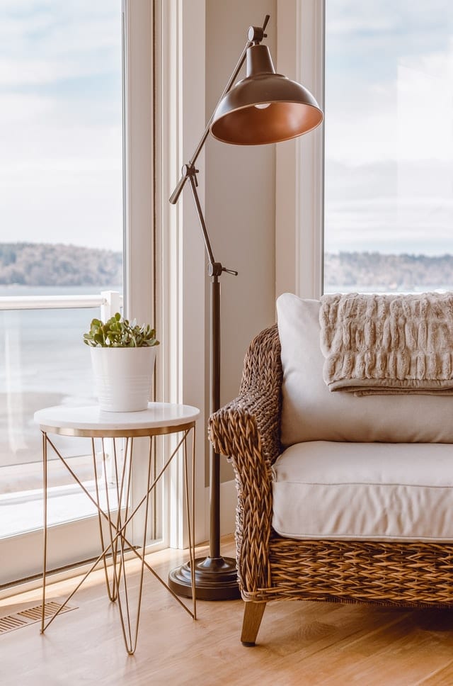 A rattan reading chair for a reading corner beside a floor lamp