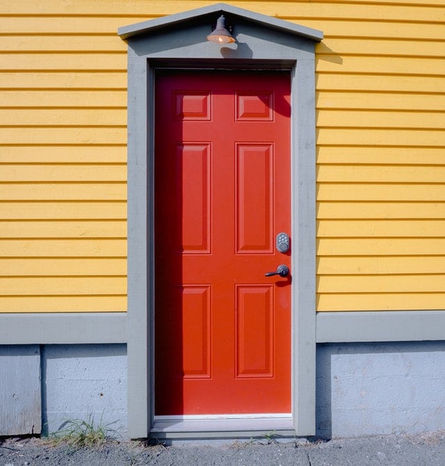 red wooden door A red wooden door with a contrasting yellow wall.