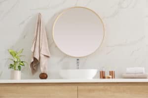 A round mirror with white trim on a