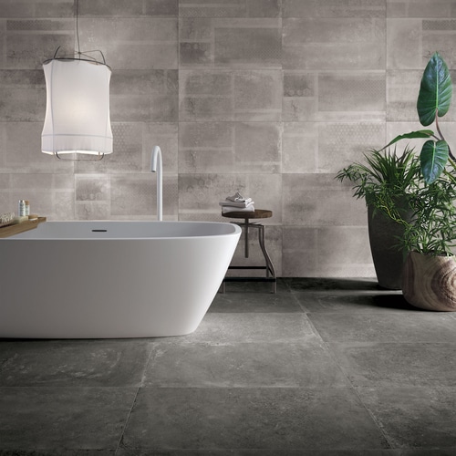 A modern bathroom with a classic white tub and seamless gray stone tiles.