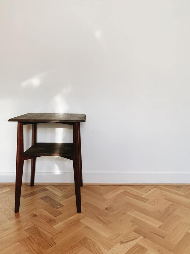 A wooden single chair against a white wall