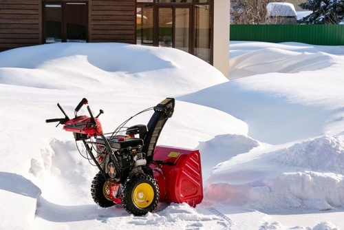 A red snow blower machine in some thick snow