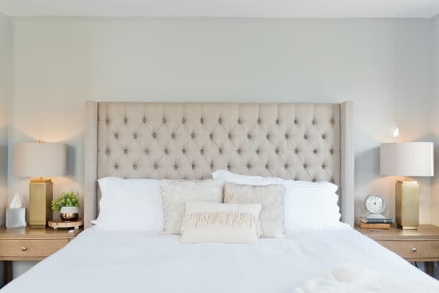 An extra large tufted bed headboard white sheets