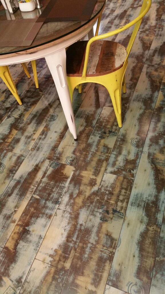 A yellow dining chair on a unique wooden plank flooring