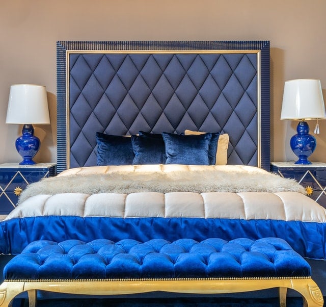 Royalty themed bedroom using velvet blue and white beddings and headboard.