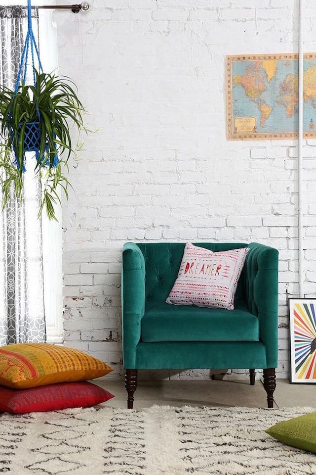 velvet chair and colorful throw pillows