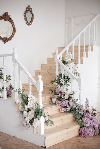 simple white stair decorated by wedding flowers