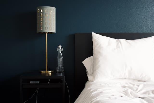 gray lamp placed beside the white pillow