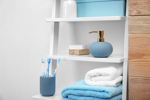 A simple white bathroom and ladder storage with touch of blue elements.