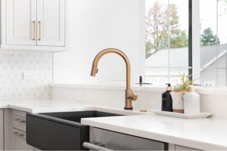 A White kitchen counter with gold faucet