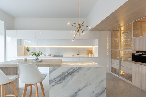 A luxury kitchen with lightwood, clean white and marble elements.