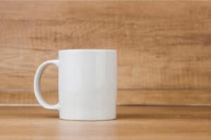 A plain white mug on a wooden kitchen table