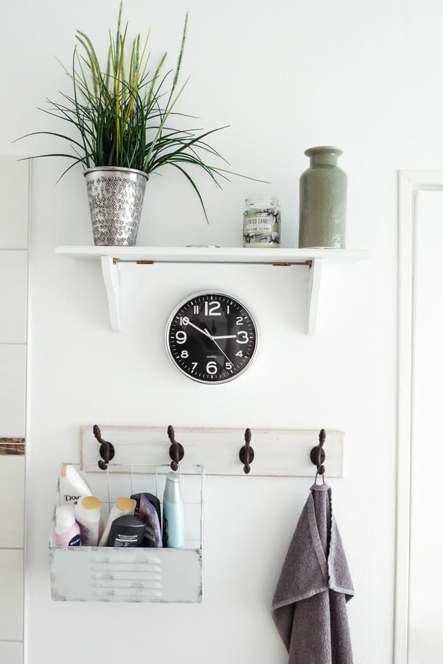 White wall shelf with hanging toiletries