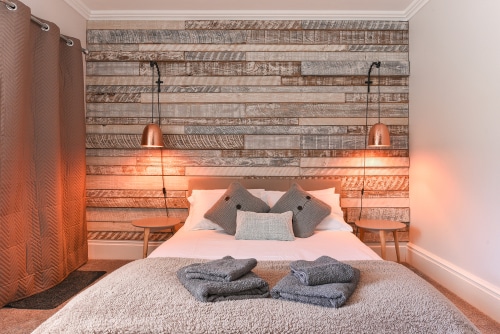 A simple bedroom with an accent headboard using painted wooden planks.